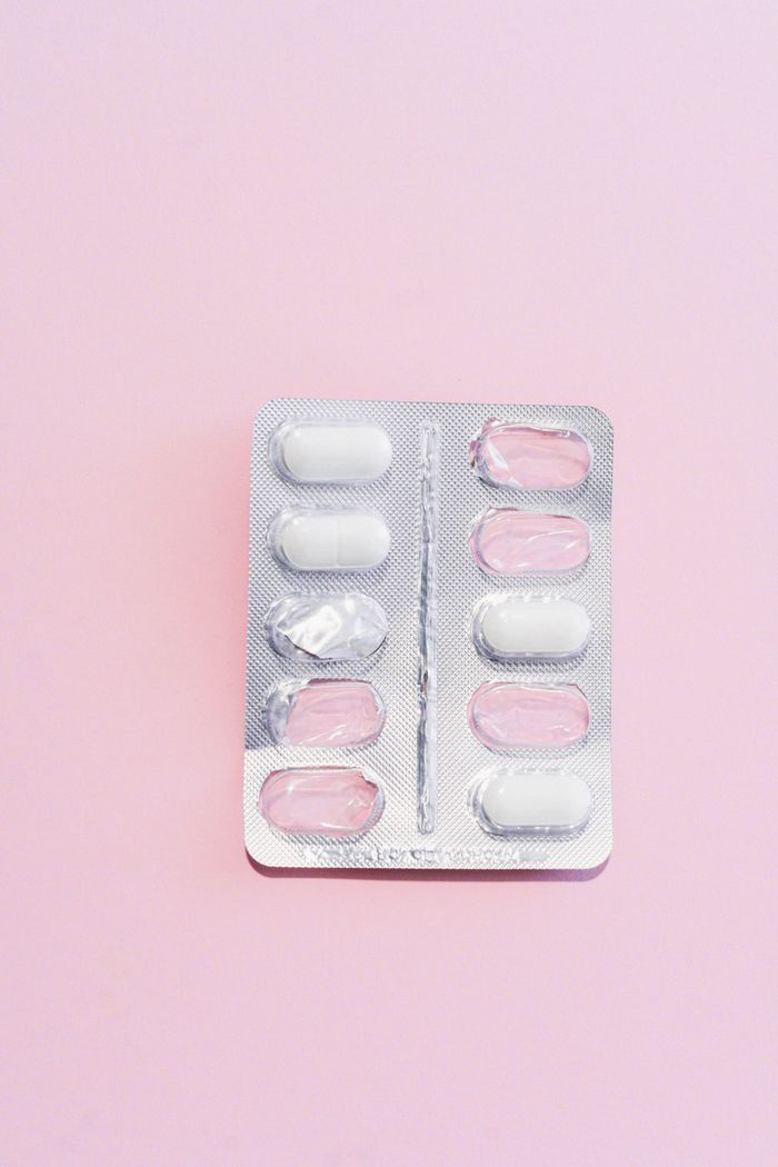 Services Close-up of a blister pack with white pills on a pastel pink background, perfect for healthcare themes.